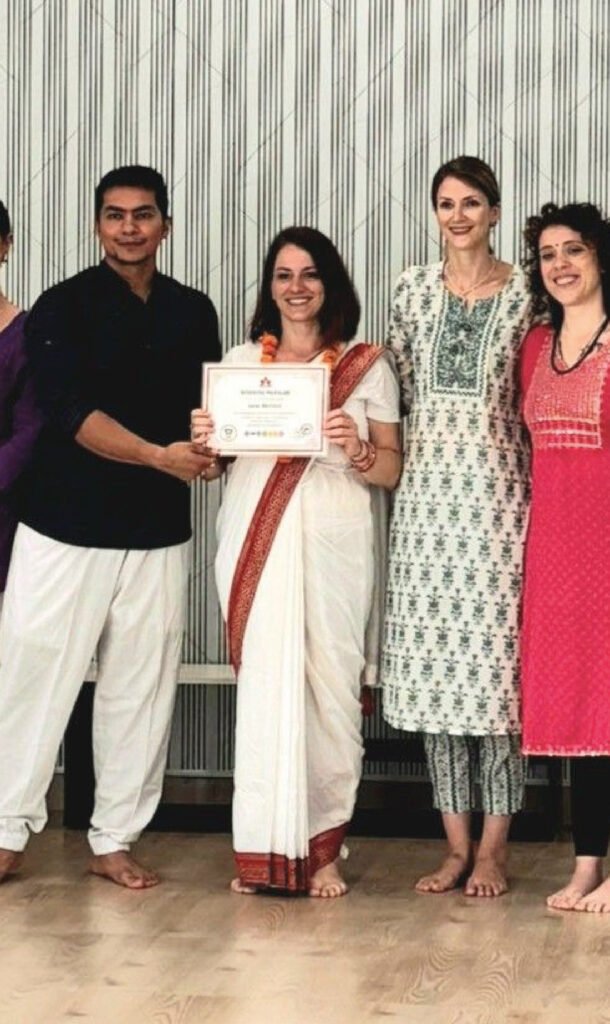 Luciana recevant son diplôme de l’Alliance de Yoga à Rishikesh, certification en yoga et bien-être spirituel en Inde.